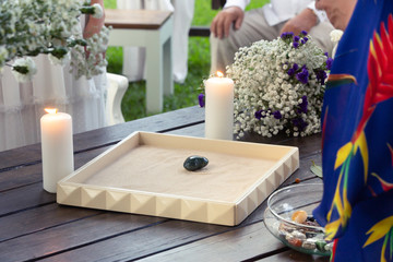 Wedding flower decoration with light up candles on a wooden table. Wedding background. Outdoor marriage ceremony. Wedding day concept. Wedding bouquet of flowers.