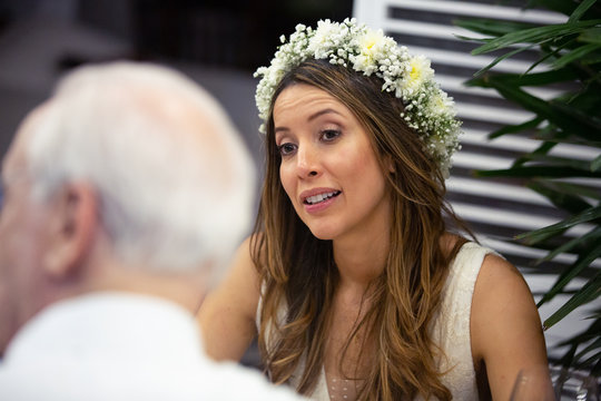 Wedding hairstyle bride with a flower crown. Beautiful bride with a love expression on her face on her outdoor marriage ceremony. Casual brunette bride on a wedding dress. Happily ever after concept.