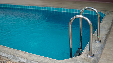 Grab bars ladder in the blue swimming pool