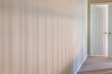Carpet floor in home room by railing stairs in hall hallway of house with shadows of banisters bars