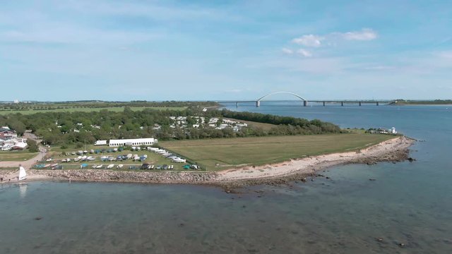 droneshot of a campsite at the beach, with lighthouse on a sunny day