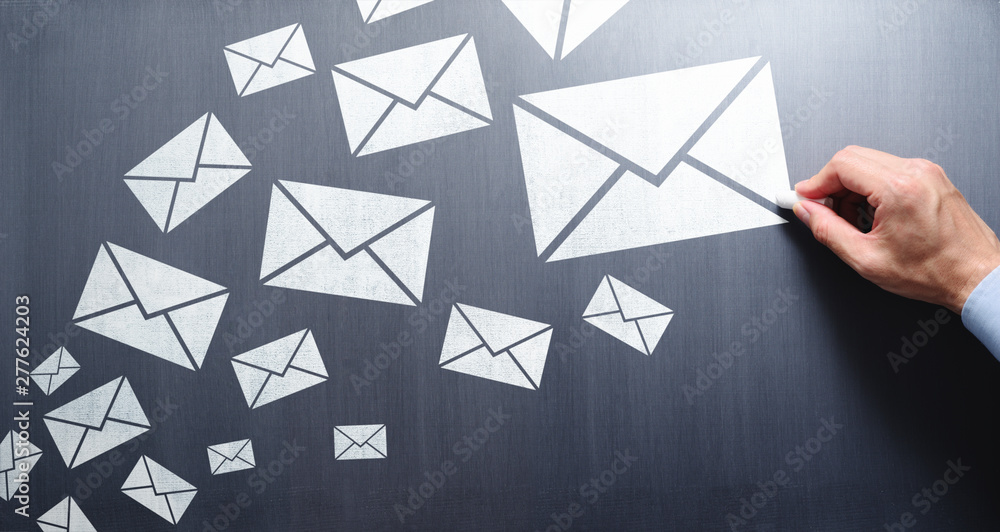 Poster writing and sending a lot of e-mail concept. businessman drawing e-mail icons on chalkboard.