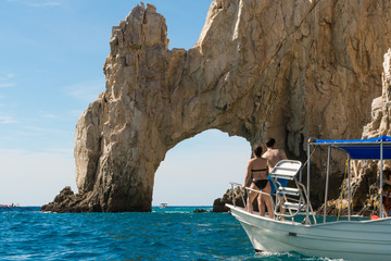 Los turistas desde la lancha están apreciando el arco de Cabo San Lucas México.