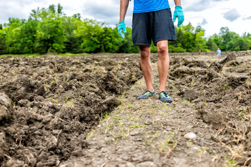 Man legs walking searching for minerals brown soil in Arkansas dirt landscape meadow field in Crater of Diamonds State Park © Kristina Blokhin
