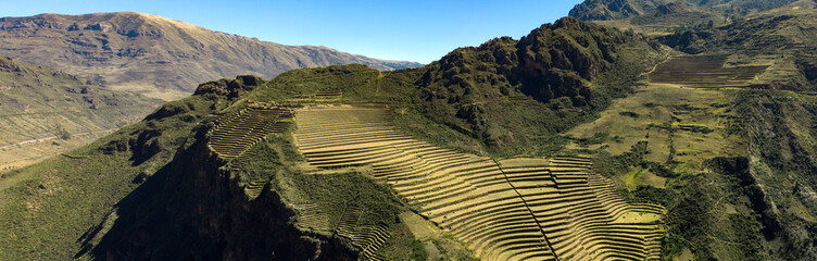 Aerial panoramic view of the ancient Inca ruins of Pisac (Pisaq) in the Sacred Valley near Cusco, Peru. Archaeological park with green terraces.