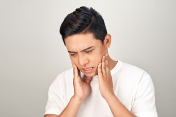 Portrait of Asian men with worry eyes use hand touching his cheek , feelings pain from toothache. Tooth and mouth disease concept.