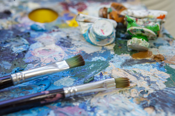 Abstract artistic background from an old palette with paints dried on it.