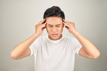 People, stress, tension and migraine concept. Upset unhappy young man squeezing head with hands,...