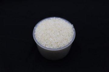 Thai white jasmine rice cup on a black background