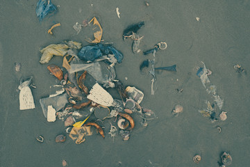 Trash, plastic, garbage, bottle, bag... environmental pollution on sandy beach. Royalty...