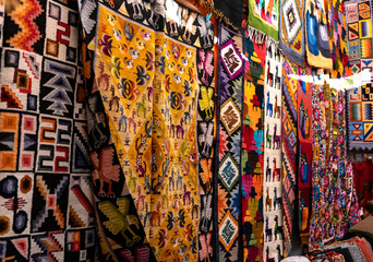 Colorful Peruvian artisanal textiles cloth with inca and traditional patterns at street Andean market in Pisac, sacred valley, Peru. - obrazy, fototapety, plakaty
