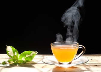 Hot tea in a glass with smoke on wood background. Hot drink . Copy space. 