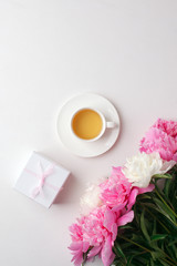 Breakfast for Valentines day with cup of tea, giftbox, flowers on white table from above in flat lay style, seasonal springtime holiday background
