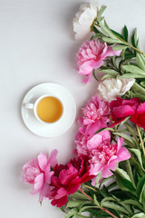 Creative layout with pink white peonies flowers and cup of tea on bright table. Spring Seasonal valentine, woman, mother, 8 march holiday, romance breakfast