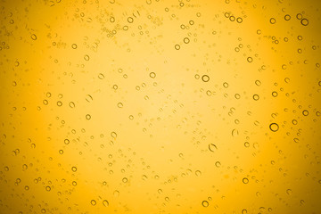 Water drops on yellow glass, Rain droplets on glass background.