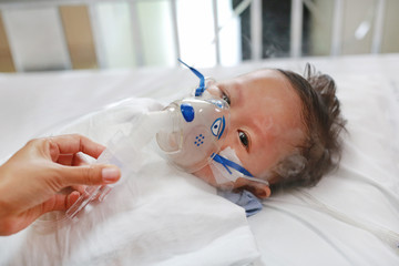 Baby has asthma and need nebulizations, Sick boy inhalation therapy by the mask of inhaler. Baby...