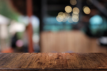 Empty dark wooden table in front of abstract blurred bokeh background of restaurant . can be used for display or montage your products.Mock up for space.