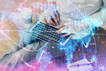 Double exposure of businessman working on laptop on background. International business hologram in front. Concept of success.