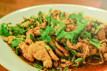 spicy pork salad, Thai northeast food, with vegetable in white plate, close up shot in warm light