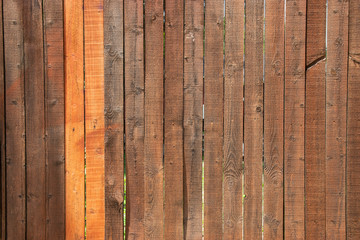Dark stained wood fence with two lighter slats