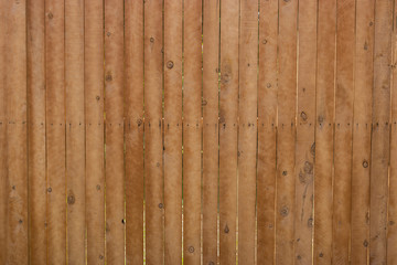 Pattern of brown, vertical wood slats in fence