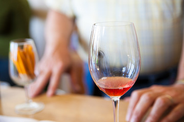 Glass of Red Wine on a Table in Restaurant with Person in Background