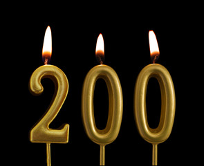 Golden birthday candles isolated on black background, number 200