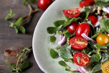 salad with purslane and cherry tomatoes.  concept of organic food from the environment. edible weeds and grass. Purslane is a useful herb. eat the weeds, wild food, eat wild food, wild greens