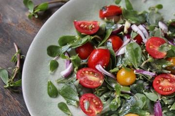 salad with purslane and cherry tomatoes.  concept of organic food from the environment. edible weeds and grass. Purslane is a useful herb. eat the weeds, wild food, eat wild food, wild greens