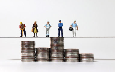 The pile of coins of different heights and various miniature people.
