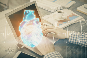 Heart drawing with man working on computer on background. Medical concept. Double exposure.