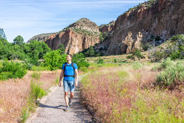 Naklejka premium Main Loop path trail with man walking in Bandelier National Monument in New Mexico in Los Alamos with canyon cliffs