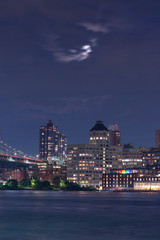Obraz premium View on Dumbo from East River with full moon 