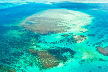 Naklejka na ściany i meble Coral reefs and atolls in the tropical sea, top view. Turquoise sea water and beautiful shallows. Philippine nature. Sea surface.