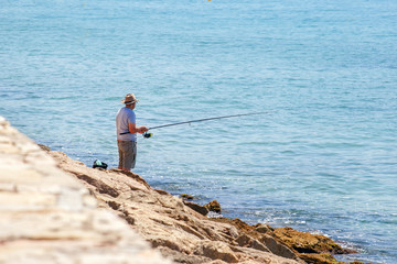 Fototapeta na wymiar Senior man fishing at sea. Fishing concept.