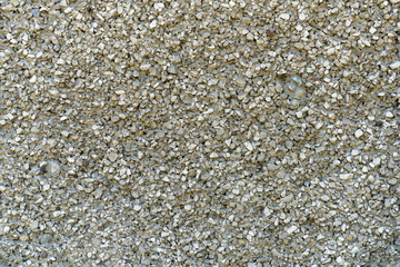 fine gravel road surface. Small stone glued with concrete. Small gravel pavement. Background type view of small rocks on a pavement road.