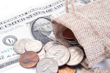 Money, US Dollars bank notes, penny, nickel, dime, quarter on a white background.