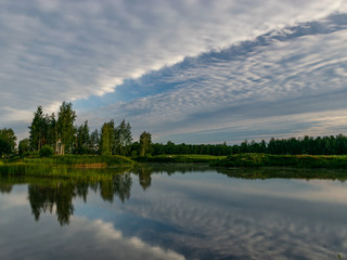 Fototapeta na wymiar Sunlight and cloud formations in the sky and water , Latvia