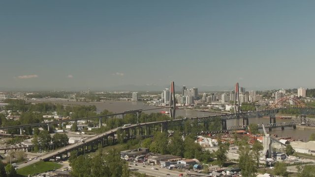 Aerial view of Pattullo and the Skytrain Bridge going over Fraser River from Surrey to New Westminster during a sunny day. Taken in Greater Vancouver, British Columbia, Canada.