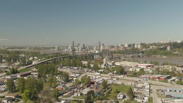 Aerial view of Pattullo and the Skytrain Bridge going over Fraser River from Surrey to New Westminster during a sunny day. Taken in Greater Vancouver, British Columbia, Canada.