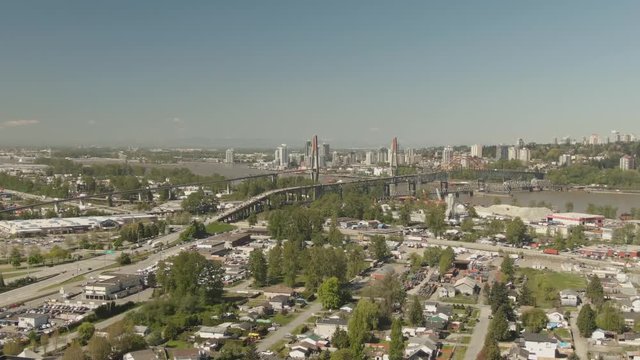 Aerial view of Pattullo and the Skytrain Bridge going over Fraser River from Surrey to New Westminster during a sunny day. Taken in Greater Vancouver, British Columbia, Canada.