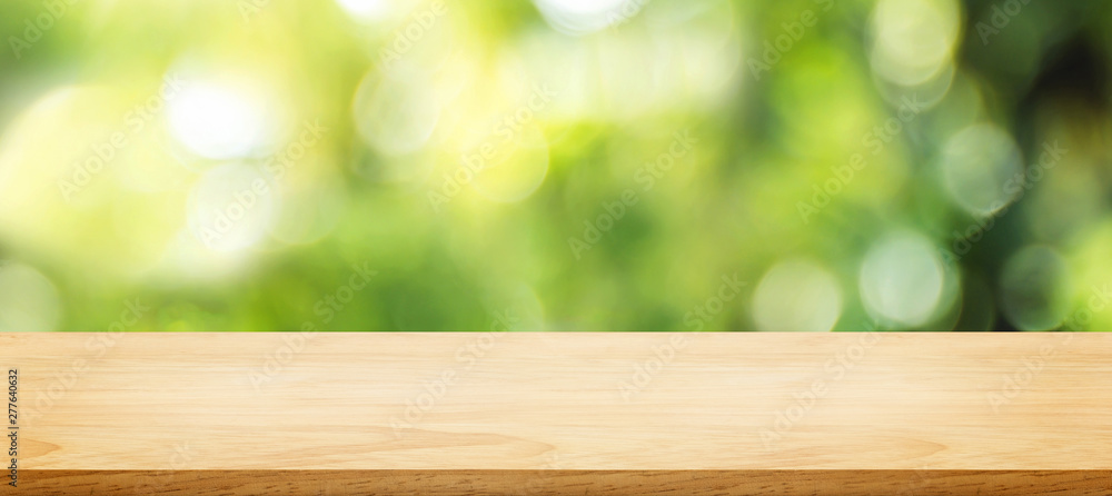 Aufkleber wooden plank table top with blur tree in park with bokeh light at background,mock up template for di