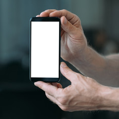 Technical service. Closeup of white mockup smartphone screen in man hands. Copy space.