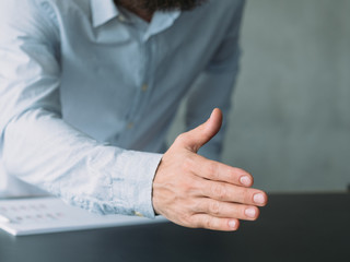 Fototapeta premium Business conference. Cropped shot of manager holding out hand to greet participants. Copy space.