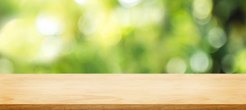 wooden plank table top with blur tree in park with bokeh light at background,Mock up template for display of your design,Banner for advertise of product