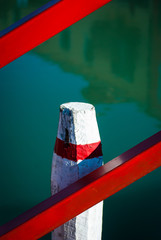 Una briccola, tipico palo della laguna di Venezia, dipinta di bianco e rosso a Burano