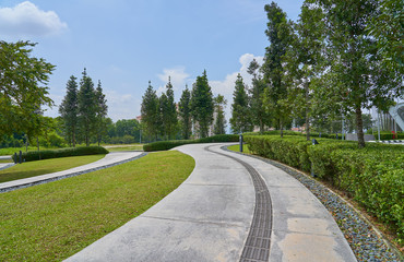 The stone walk path way  in the park with green grass background .