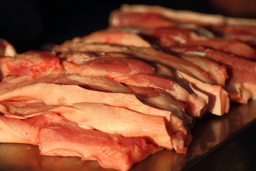 Cutting streaky pork in fresh market,close up Pork belly.