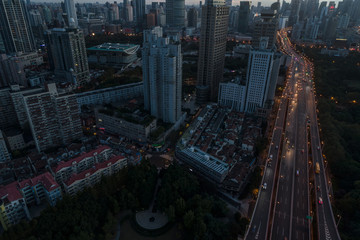 aerial view of buildings and highway interchange at dawn in Shanghai city