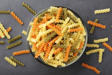 A bowl with uncooked pasta fusilli tricolor
